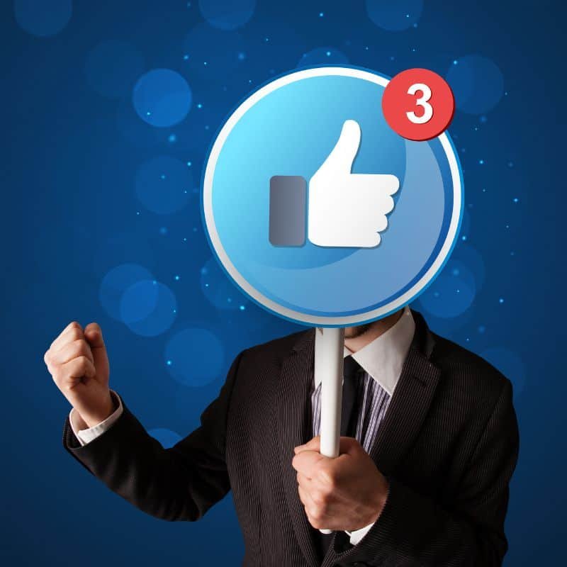 business man holding facebook like symbol