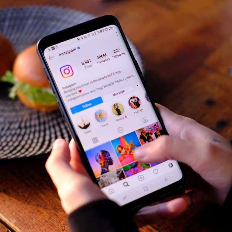 person on smartphone looking at Instagrams Instagram profile